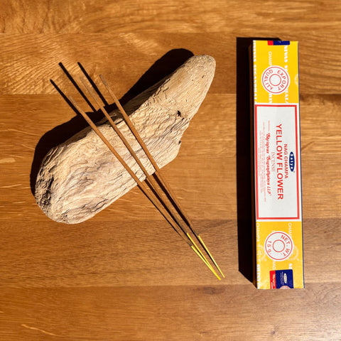 Satya Yellow Flower Incense Sticks 15g box on a wooden background, with a bright and uplifting floral fragrance.