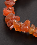 Carnelian Chip Bracelet — closeup image of a stretch bracelet made of natural orange-red carnelian crystal chips, known for boosting confidence, creativity, and passion.