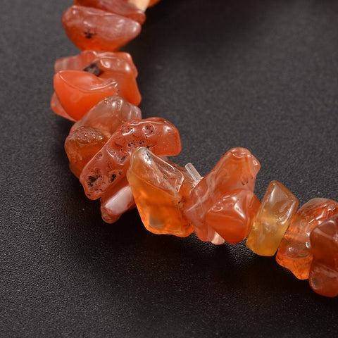 Carnelian Chip Bracelet — closeup image of a stretch bracelet made of natural orange-red carnelian crystal chips, known for boosting confidence, creativity, and passion.