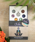 Chakra Healing Necklace Gift Set displayed on wooden surface with packaging and pendant