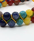 Detail image of Chakra Super Powerball Bracelet with polished gemstone beads on a white background.