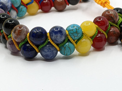 Detail image of Chakra Super Powerball Bracelet with polished gemstone beads on a white background.