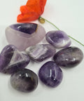 Chevron amethyst tumbled stone showing purple and white banding on white background — Fragrant Heaven