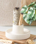 Cream Ribbed Smudge Bowl displayed with sage and palo santo on a wooden surface.