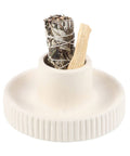 Close-up of Cream Ribbed Smudge Bowl holding a sage bundle and palo santo stick.