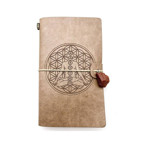 Esoteric 7 Chakras leatherette notebook with Flower of Life design and crystal charm, used for journaling, meditation notes, dream recording, and spiritual study.