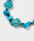 Detail of Blue Howlite chip and turtle thread bracelet symbolising calm, protection, and wisdom. Adjustable cord design associated with the Throat Chakra.