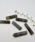 Labradorite crystal point with iridescent flashes symbolising protection, intuition, and transformation. Associated with the Crown, Throat, and Third Eye Chakras.