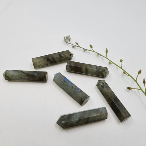 Labradorite crystal point with iridescent flashes symbolising protection, intuition, and transformation. Associated with the Crown, Throat, and Third Eye Chakras.