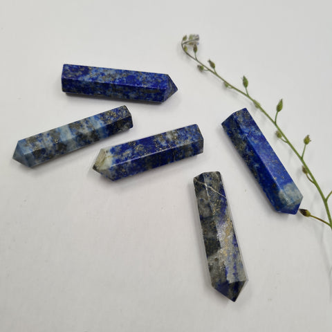 Lapis Lazuli crystal point with deep blue and gold flecks symbolising wisdom, intuition, and clear communication. Associated with the Third Eye and Throat Chakras.