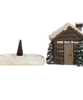 Log cabin incense holder shown with incense cone on snowy base.