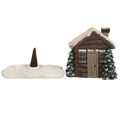 Log cabin incense holder shown with incense cone on snowy base.