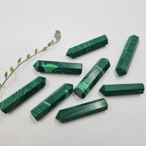 Malachite crystal point with rich green patterns symbolising protection, transformation, and emotional balance. Associated with the Heart Chakra and signs Taurus, Capricorn, Libra, and Scorpio.