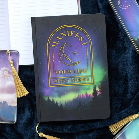 Manifest Your Life Weekly A5 Planner on desk with celestial design and gold foil moon.