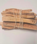 Twelve palo santo holy wood sticks tied with natural twine on white background — Fragrant Heaven Ireland