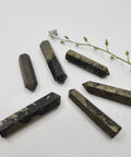 Pyrite crystal point with metallic gold tones symbolising luck, protection, and abundance. Associated with the Solar Plexus and Base Chakras and the astrological sign Leo.