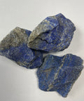 Three raw lapis lazuli pieces showing natural deep blue colour and gold pyrite flecks on white background — Fragrant Heaven