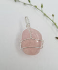 Rose Quartz Gemstone Pendant with a soft pink hue on a white background.