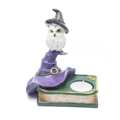 Resin owl candle holder with purple witch’s hat and book base, symbolizing wisdom, intuition, and spiritual connection in Wicca. Holds a tealight candle.